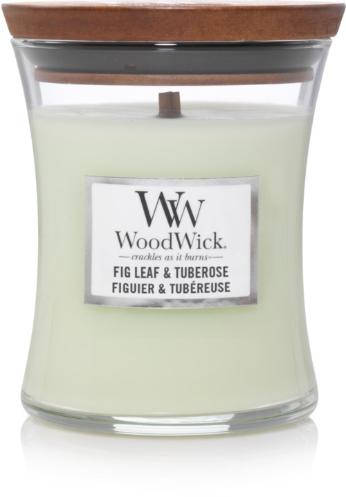 Ett vitt ljus i en glasburk med ett trälock, märkt "WoodWick" och doft "Fig Leaf & Tuberose."