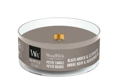 Et lite svart lys i en metallbeholder med en gullfarget veke og svart etikett. Det heter WoodWick, med sitronduft.