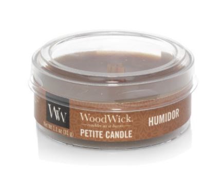 En liten ljuslykta i tydligt plastfodral med brun etikett, kallad WoodWick, doft av Humidor.