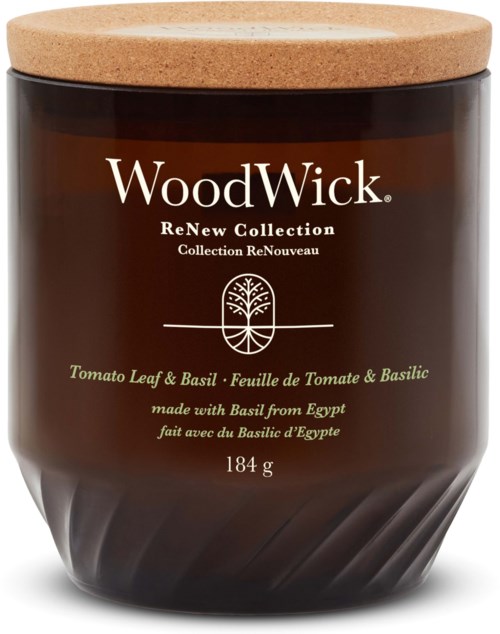 Ett brunt ljuslyktor med korklocka, märkt 'WoodWick' och nämner 'Tomato Leaf & Basil,' tillverkat med basilika från Egypten.