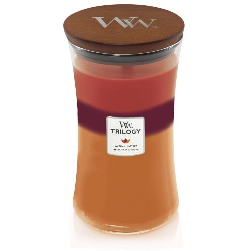En flerradig doftljus med trälocket, märkt Vanilla Woods, i en glasburk. Den har nyanser av kräm, rosa, rött och orange.