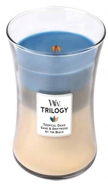 Ett doftljus i glasbehållare med en blå och beige del, märkt 'Trilogy Tropical Oasis' och beskrivning.
