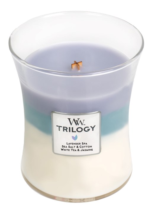 En doftljus märkt "Trilogy" med lavendel, havssalt, bomull, vitt te och jasmin doft, i glasbehållare.