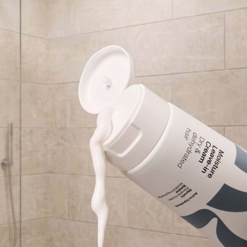 Vit flaska av Neutrogena Chinese Leav på badrumsväggen med lotion som rinner ut ur öppningens lock.
