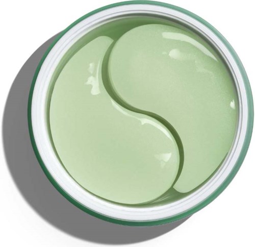 En rund grön behållare med en yin-yang-symbol inuti, vilande på en skuggad yta.