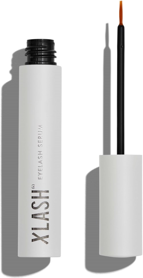 A white tube with a black cap and an orange brush, likely an eyelash serum or makeup product. Shadow shows it's sunny.
