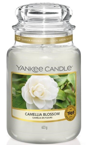En Yankee Candle-krukke med duft af hvid Kameliablomst, med grønne blade på etiketten og guld detaljer rundt om låget.
