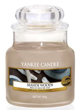 Eine Yankee Candle-Glas mit der Aufschrift 'Seaside Woods', hellbeige Wachs und transparentem Deckel.
