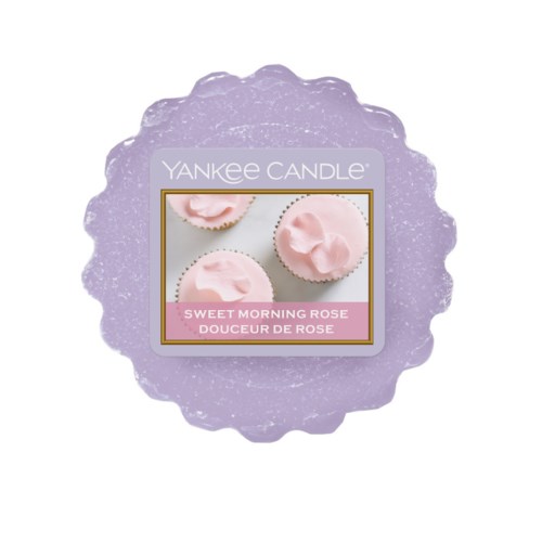 En lavendelfärgad ljus med en etikett som visar rosa bakverk och texten "Sweet Morning Rose."