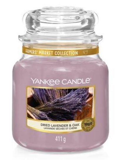 Różowa świeca zapachowa w szklanym słoiku z etykietą lawenda i dąb, marka Yankee Candle, 411 gram.
