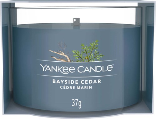 En Yankee Candle-behållare märkta 'Bayside Cedar' med trädillustration och vikt av 37g.