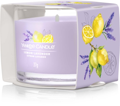 En lavendelluktande och citrondoftande ljus i en lila glasbehållare med lavendel- och citronillustrationer på förpackningen.