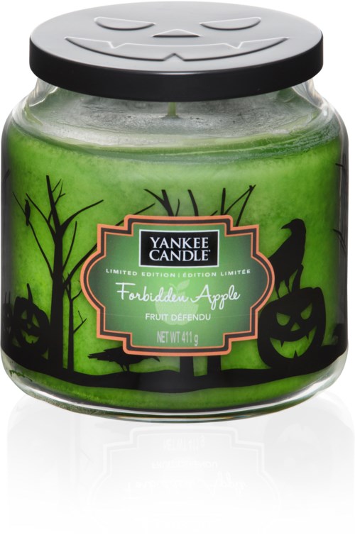 Grön doftljus i burk med Halloween-tema i svart och en label som säger 'Forbidden Apple'.