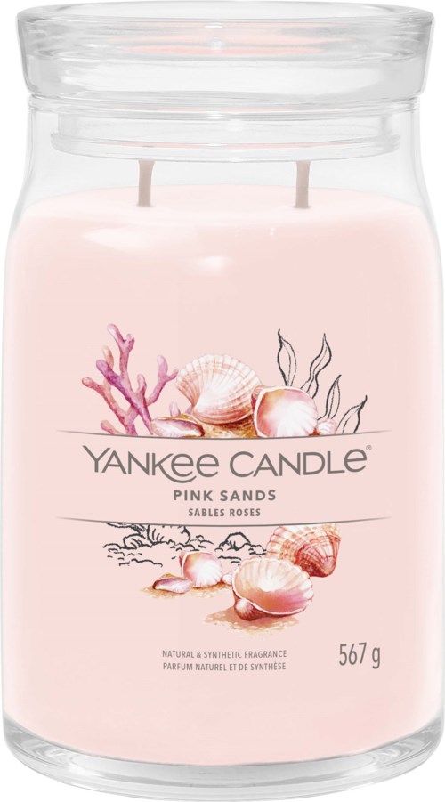Eine rosa Duftkerze in einem Glas mit Muscheln und Korallen, beschriftet 'Yankee Candle Pink Sands'.