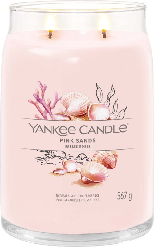 Eine rosa Kerze mit zwei Flammen, Muscheln, Korallen und Pflanzenverzierungen auf dem Etikett, genannt 'Yankee Candle Pink Sands.'