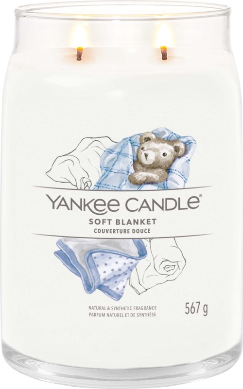 Ett Yankee Candle-glas med ett gosedjur, filmbild av filt, två tända vaxljus och 567g vikt.