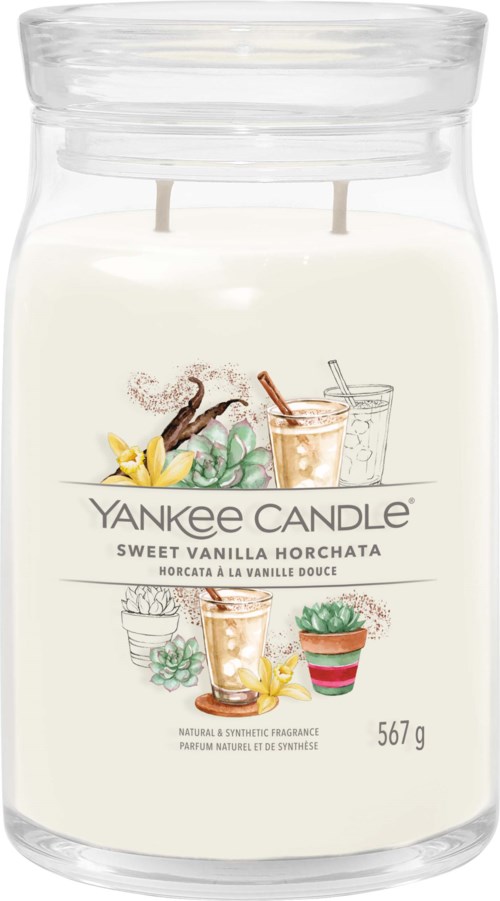 A large glass jar with white wax and a label for Yankee Candle's Sweet Vanilla Horchata scent. Contains 567 grams.