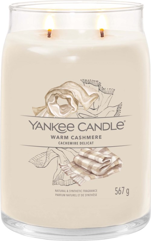 Een grote kaars met twee vlammen, gelabeled Yankee Candle Warm Cashmere, ruikt naar kasjmier met afbeelding van kasjmierstof en bloem.