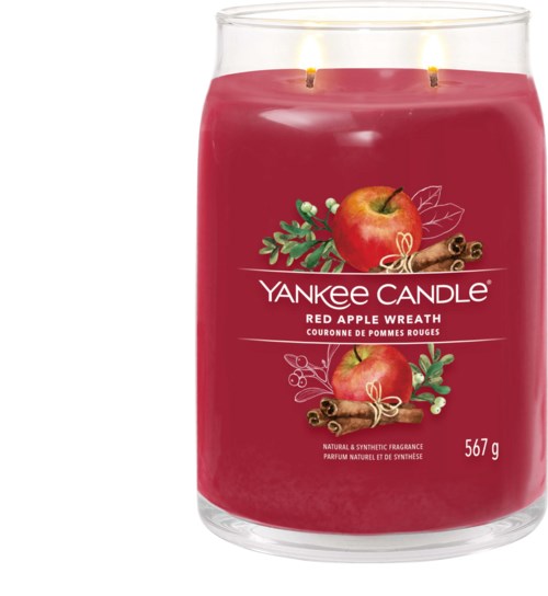 A red candle with two flames, decorated with apples, cinnamon, and greenery, labeled Yankee Candle Red Apple Wreath.