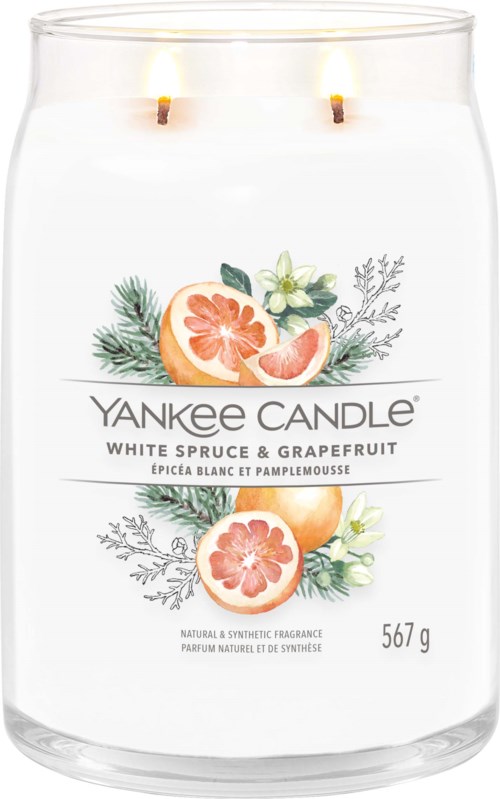 A white candle with two flames, decorated with grapefruit, greenery, and white flowers on the label.