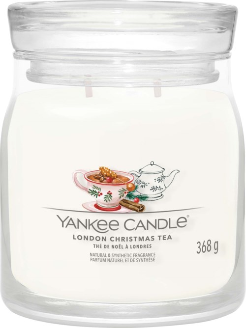 A white candle jar with Christmas tea flavor, decorated with a teapot and a cup with a Christmas pattern.