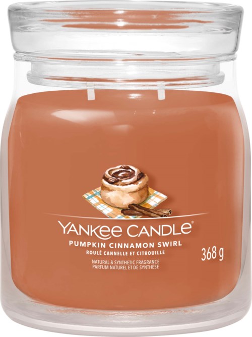 A pumpkin cinnamon scented candle in a glass jar, labeled with weight and scent details, featuring an cinnamon roll image.