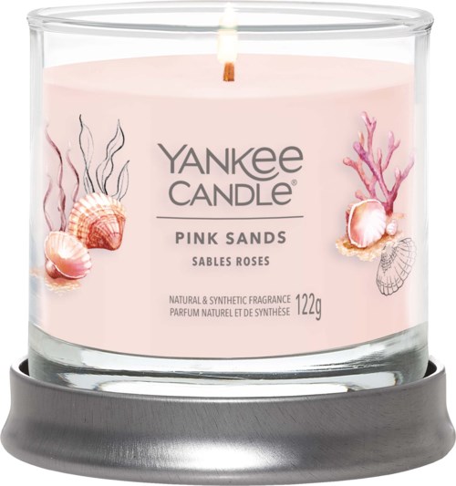 Tämä on vaaleanpunainen kynttilä, jossa on simpukoita ja koralleja, nimeltä 'Yankee Candle Pink Sands' ja sytytetty watti.