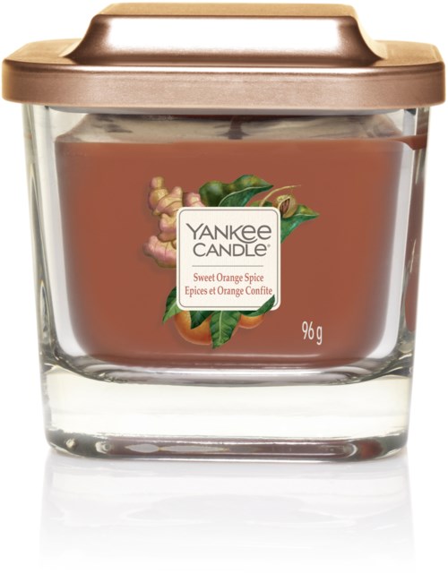 Mała świeca w szklanym słoiku z brązową pokrywką, oznaczona zapachem Yankee Candle Sweet Orange Spice, waży 96 gram.