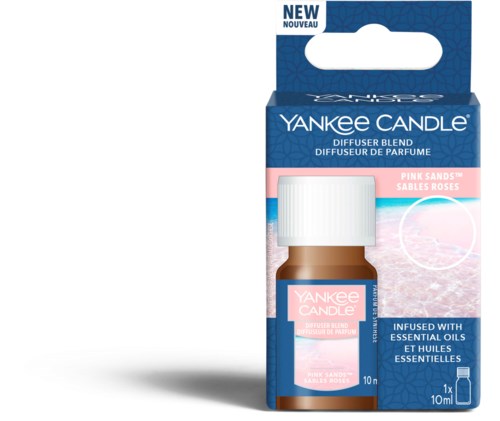 En liten brun essensiell oljeboks med hvit hette, merket 'Yankee Candle Pink Sands.' Emballasjen er blå og hvit.