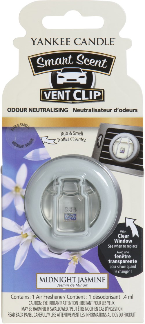En Yankee Candle ventilationsklämma med Midnight Jasmine-doft, avsedd att neutralisera dofter, fäst vid ett fönster, med blommor på förpackningen.