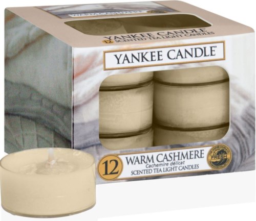 En förpackning med 12 Yankee Candle-ljus i varm kassmeresdoft, med ett ljus utanför förpackningen.