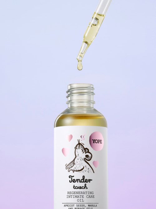 Butelka oleju z ilustracją jednorożca, różowymi sercami i pipetą nad nią. Na etykiecie jest napisane "Tender Touch".