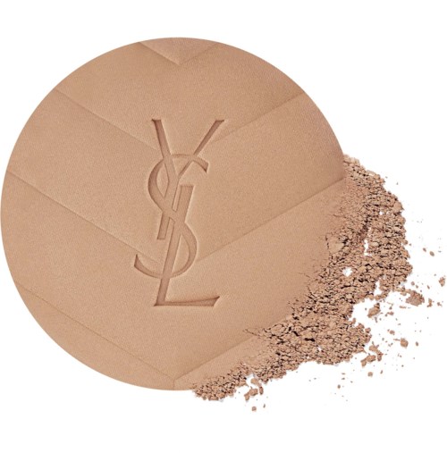 En YSL-logo sminke pulverkompakt med noe pudder spredt ved siden av.