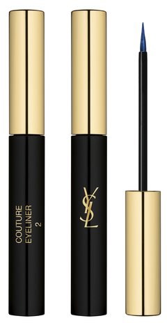 Two Yves Saint Laurent lip gloss tubes and an applicator brush stand upright.