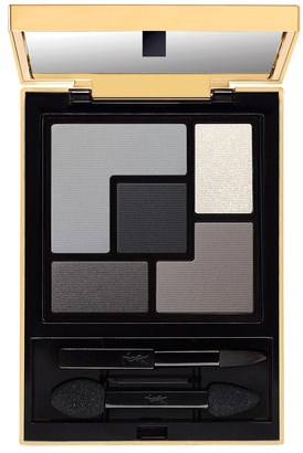 A makeup palette with different shades of gray and black eyeshadows, an applicator brush, and a mirror.