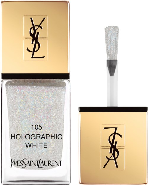 En Yves Saint Laurent neglelakkflaske med holografisk hvit farge og gullhette med logo. En børste er ved siden av.