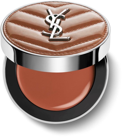 En liten makeupkompakt med YSL-logga på ett quiltat brunt lock, innehållande pressad puder-makeup.