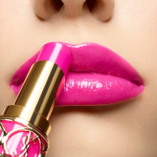 Close-up van lippen met roze lippenstift. Focus op de lippen en het aanbrengen.