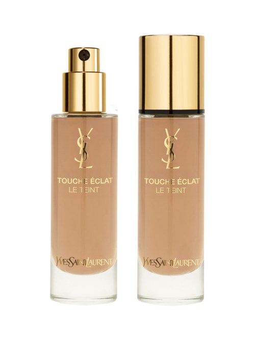 Två flaskor av Yves Saint Laurent Touché Éclat Le Teint foundation, en med spray och den andra med lock.