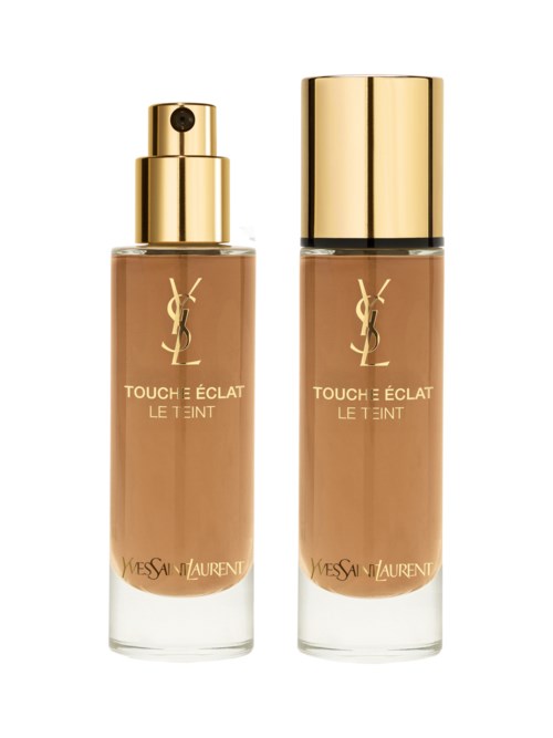 Två flaskor av Yves Saint Laurent Touché Éclat Le Teint foundation med guldkorkar och beige flytande innanför.