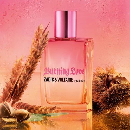 En parfyllflaske merket 'Burning Love' med rosa og oransje toner, omgitt av naturlige elementer som hvete og skjell.