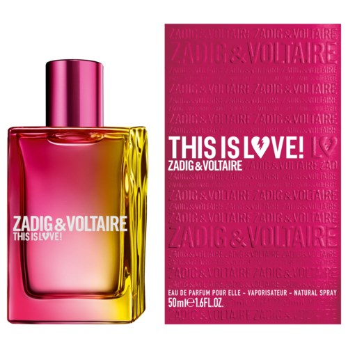 A perfume bottle with pink and yellow colors stands next to a pink box with perfume brand name and slogan.