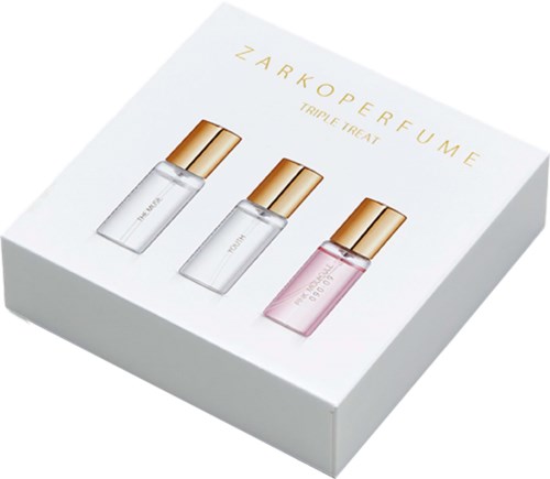 Et sett med tre parfymeflasker med gullkapsler i en hvit eske, merket ZarkoPerfume Triple Treat.