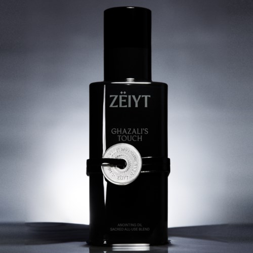 Svart flaska med Zëyt Ghazali's Touch smörjolja med ett silverringmärke i mitten.
