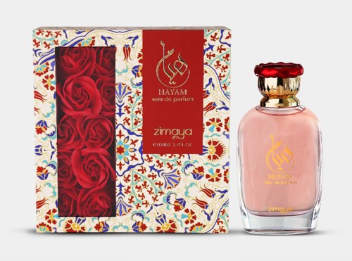 A perfume set with red roses in box, decorated with colorful patterns, and a pink perfume bottle with gold and red cap.