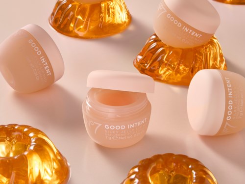 Små burkar med rosa kräm omgivna av glänsande, orange, geléliknande dekorationer. Burkarna är märkta GOOD INTENT.