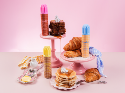 Pink, gula och blå dessertflaskor, bakverk som croissanter och pannkakor, samt en stapel brownie med gräddning.