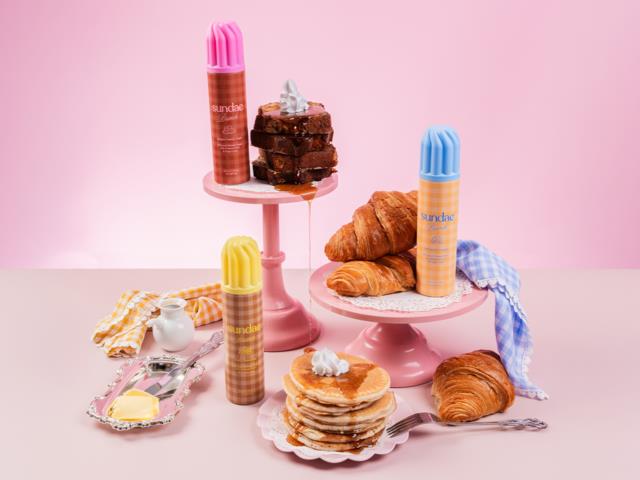 Pink, gula och blå dessertflaskor, bakverk som croissanter och pannkakor, samt en stapel brownie med gräddning.