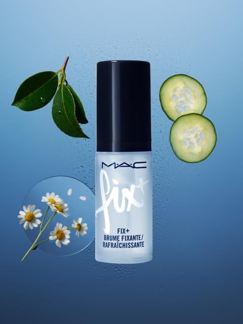 A MAC Fix+ spray bottle surrounded by cucumber slices, chamomile flowers, and green leaves on a blue background.