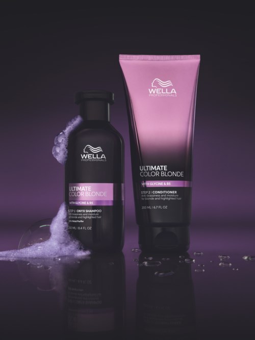 Två Wella hårvårdsprodukter, schampo i svart flaska och conditioner i rosa tub, med vattensplashar.